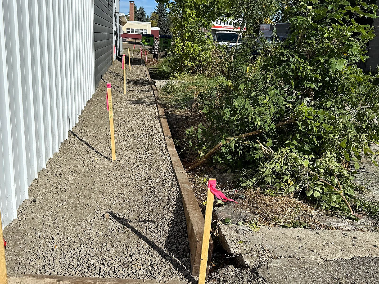 Finished gravel grade base running along a building side yard ready for final landscaping