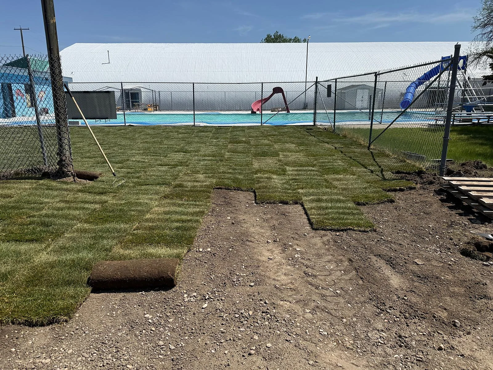 Partially installed sod showing ground preparation